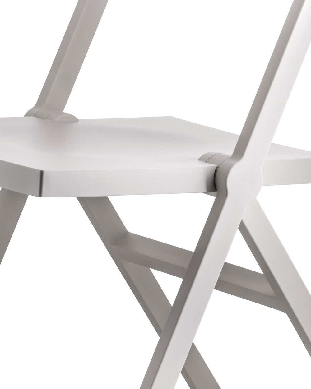 A white folding chair by Alessi, a cropped close-up showing the minimalist seat and hinge mechanism.