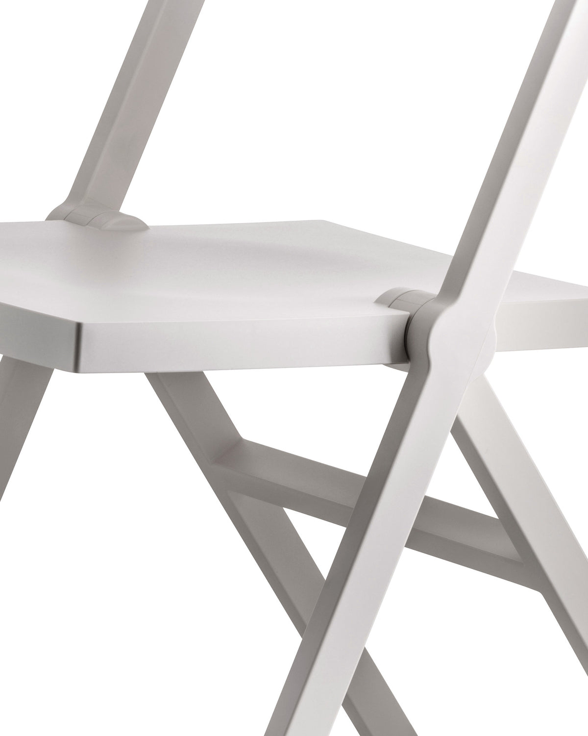 A white folding chair by Alessi, a cropped close-up showing the minimalist seat and hinge mechanism.