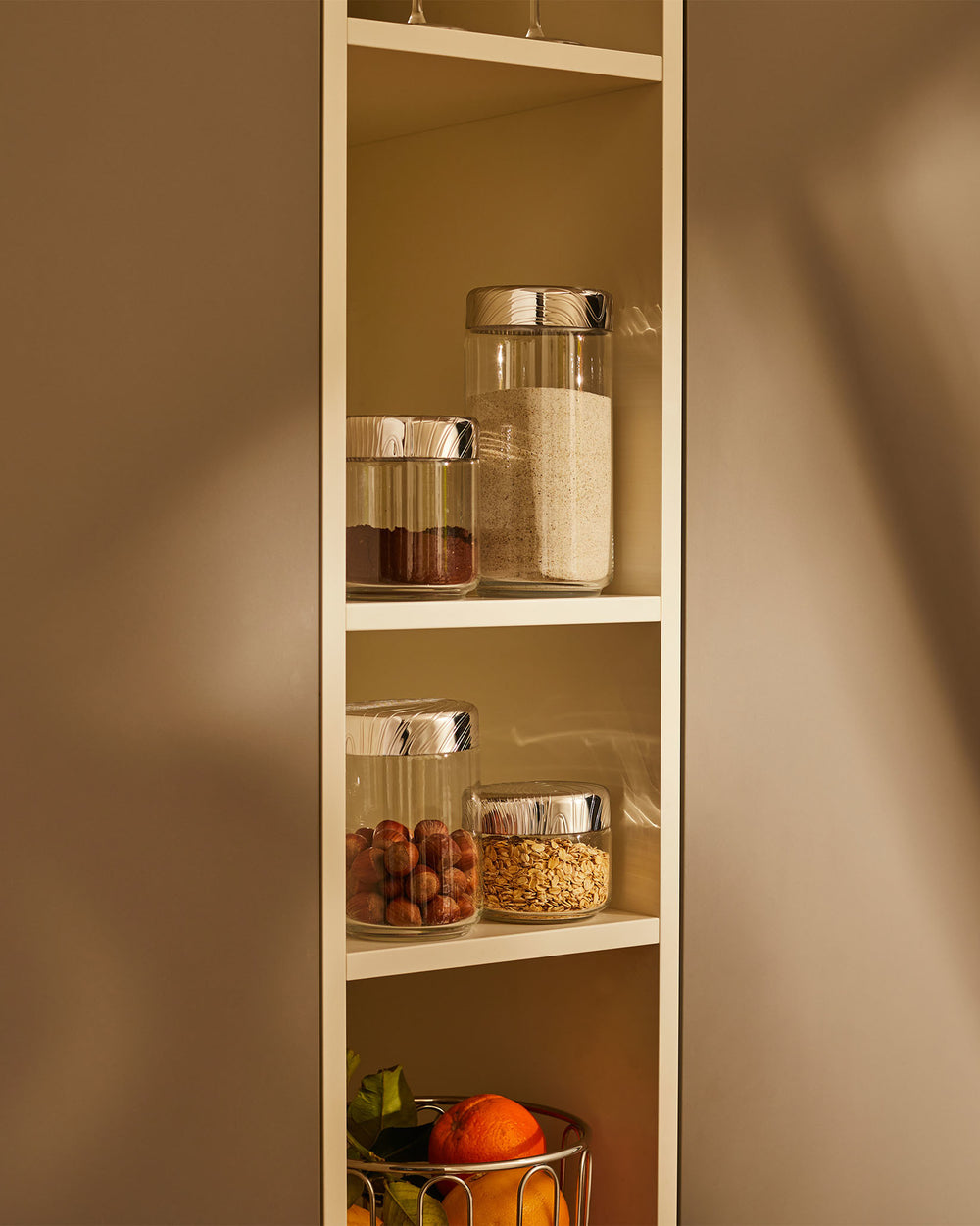 Brown veneer by Alessi on a cabinet panel with a subtle vertical grain texture, next to open kitchen shelves.