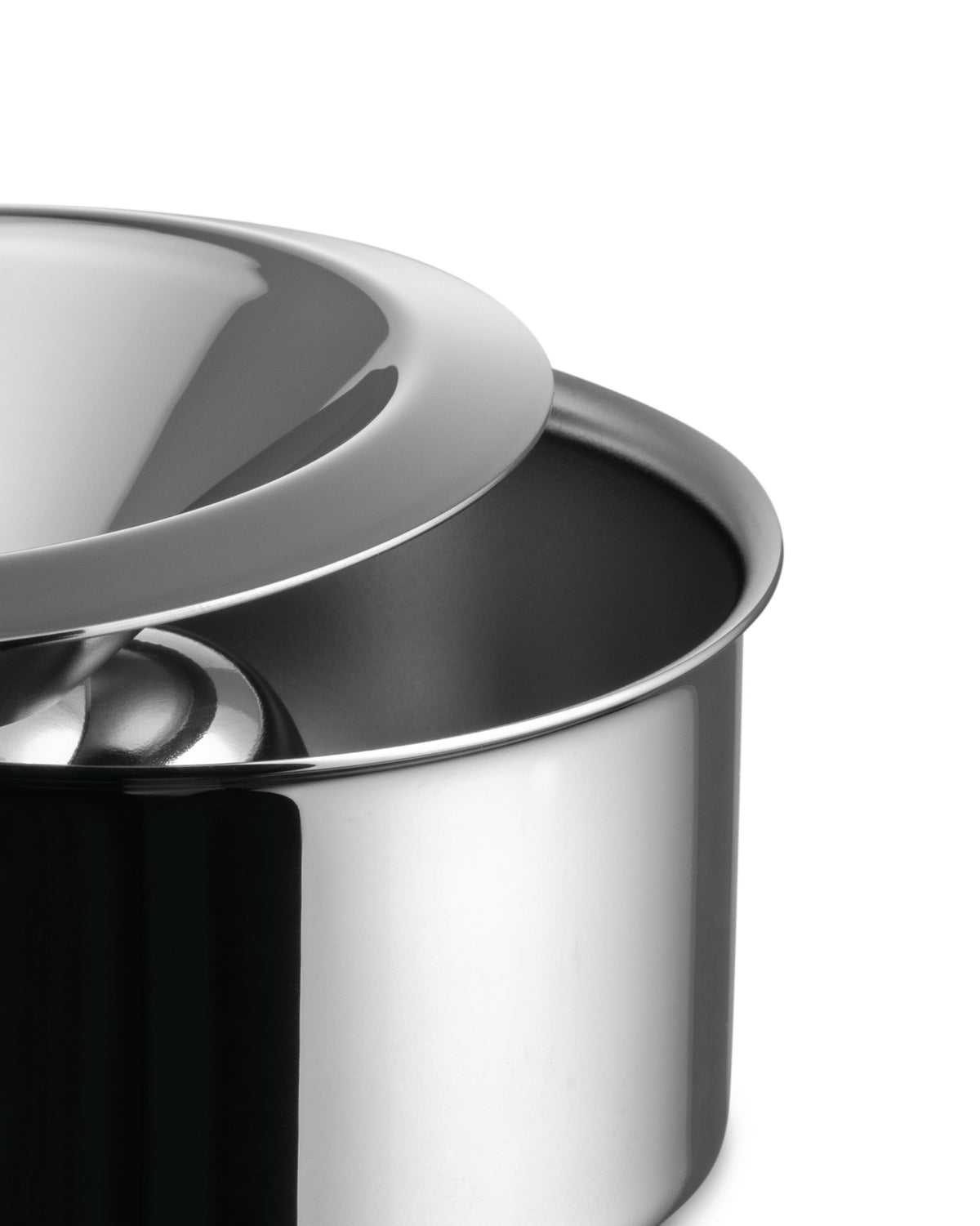 Polished stainless steel serving bowl by Alessi with a sleek, domed lid, in a close-up view.