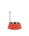 Elevated red pet bowl by Alessi with a stainless steel insert and a white bone-shaped handle.