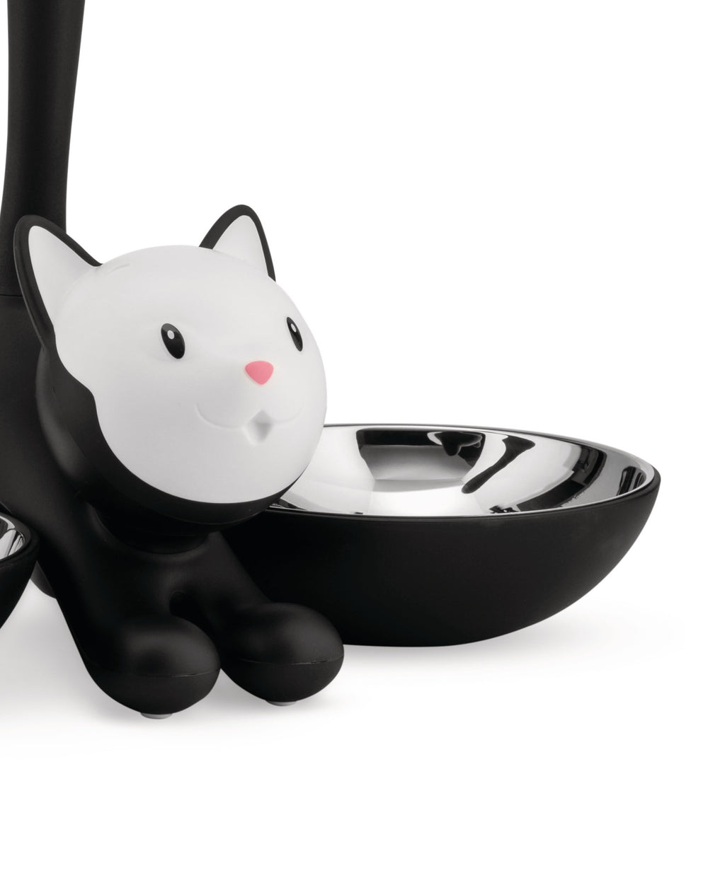 Black and white cat-shaped pet feeder by Alessi with a shiny metal bowl.