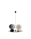 Black and cream spherical salt and pepper shakers by Alessi, on a reflective silver base with a tall central rod and black sphere top.