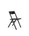 Matte black folding chair by Alessi, with a sleek, minimalist design in an angled view.
