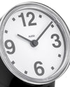 Black and white alarm clock by Alessi with bold grey numbers, a silver corrugated bezel, and black hands.