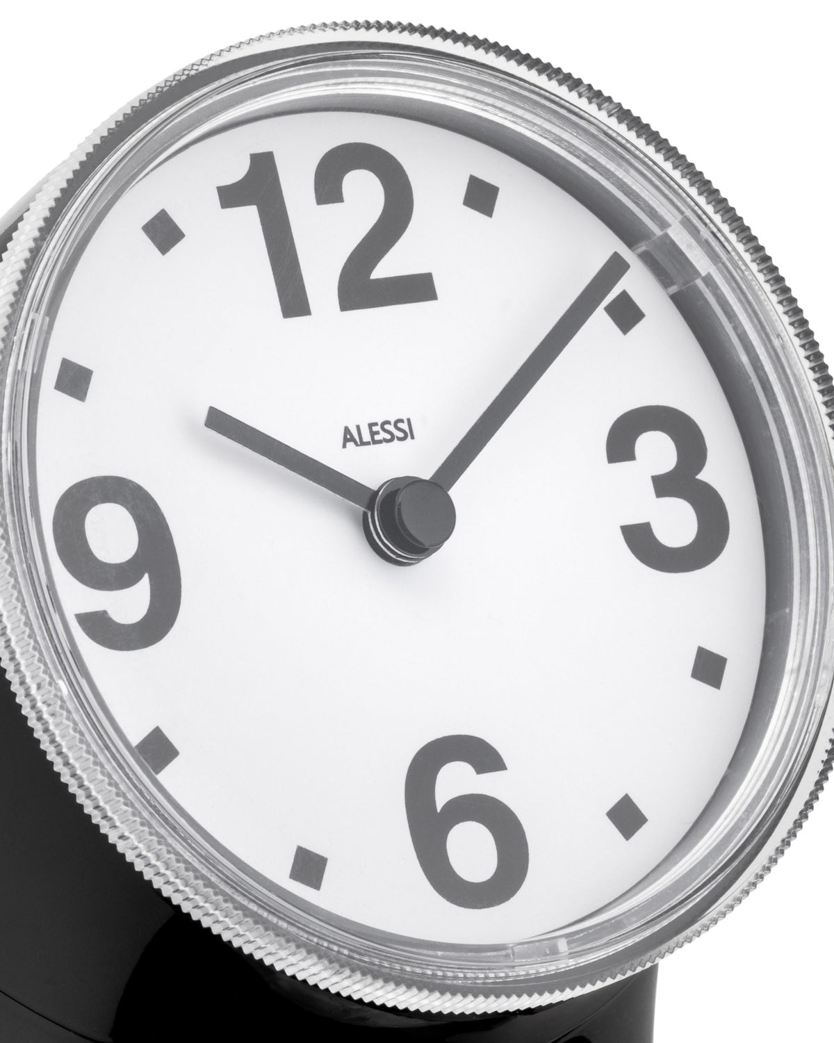 Black and white alarm clock by Alessi with bold grey numbers, a silver corrugated bezel, and black hands.