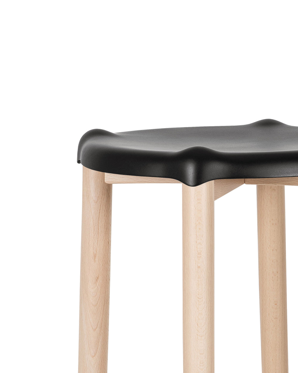 Black sculpted stool by Alessi with light wooden legs, shown in a cropped side view.