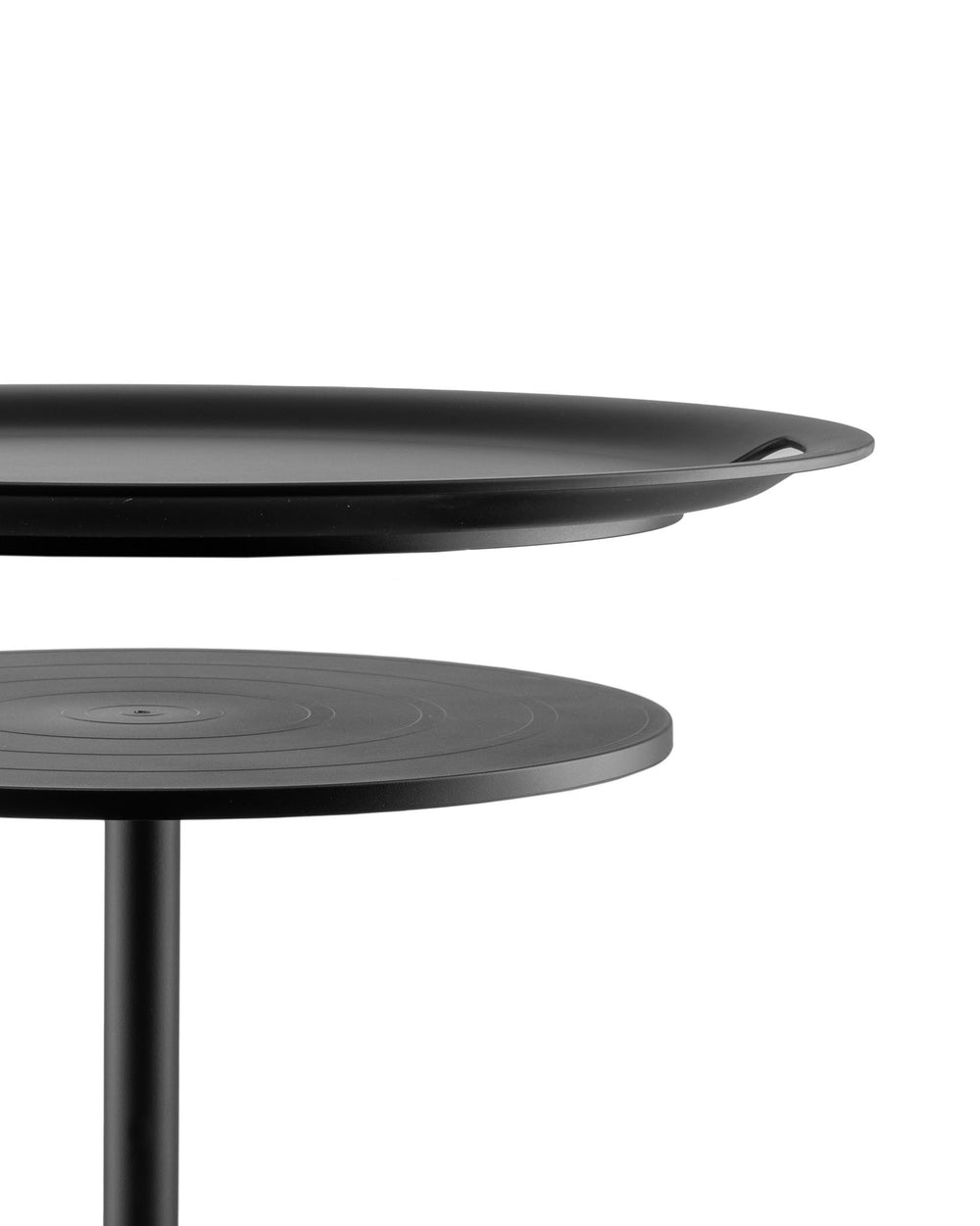 Black two-tiered serving stand by Alessi with a matte finish, featuring a tray-like top and a lower tier with concentric grooves.