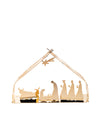 Gold-colored metal nativity crib by Alessi, featuring silhouette figures of the holy family, wise men, animals, and a comet star.