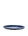 Dark blue faceted tray by Alessi with a geometric, reflective surface, isolated on white.