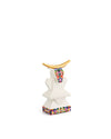 White cow sculpture with golden horns by Alessi, adorned with colorful pixelated patterns on its chest and base.