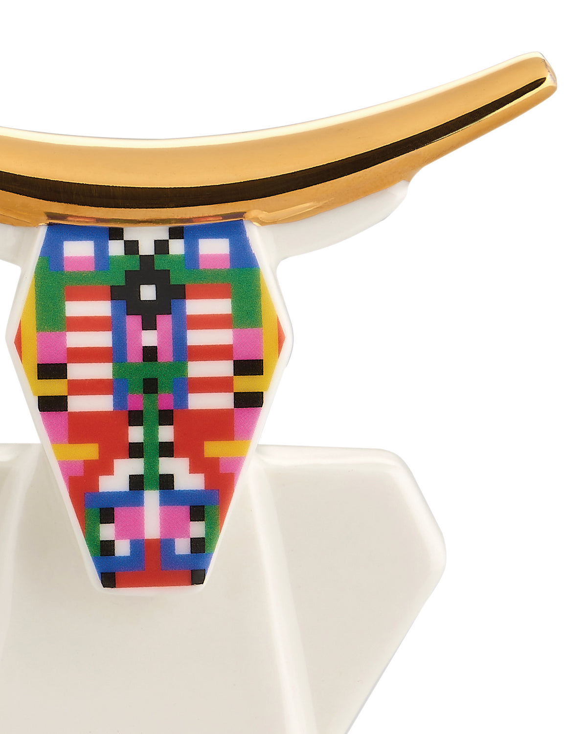 White cow figurine with golden horns by Alessi, featuring a colorful pixelated geometric pattern on its face, cropped view.