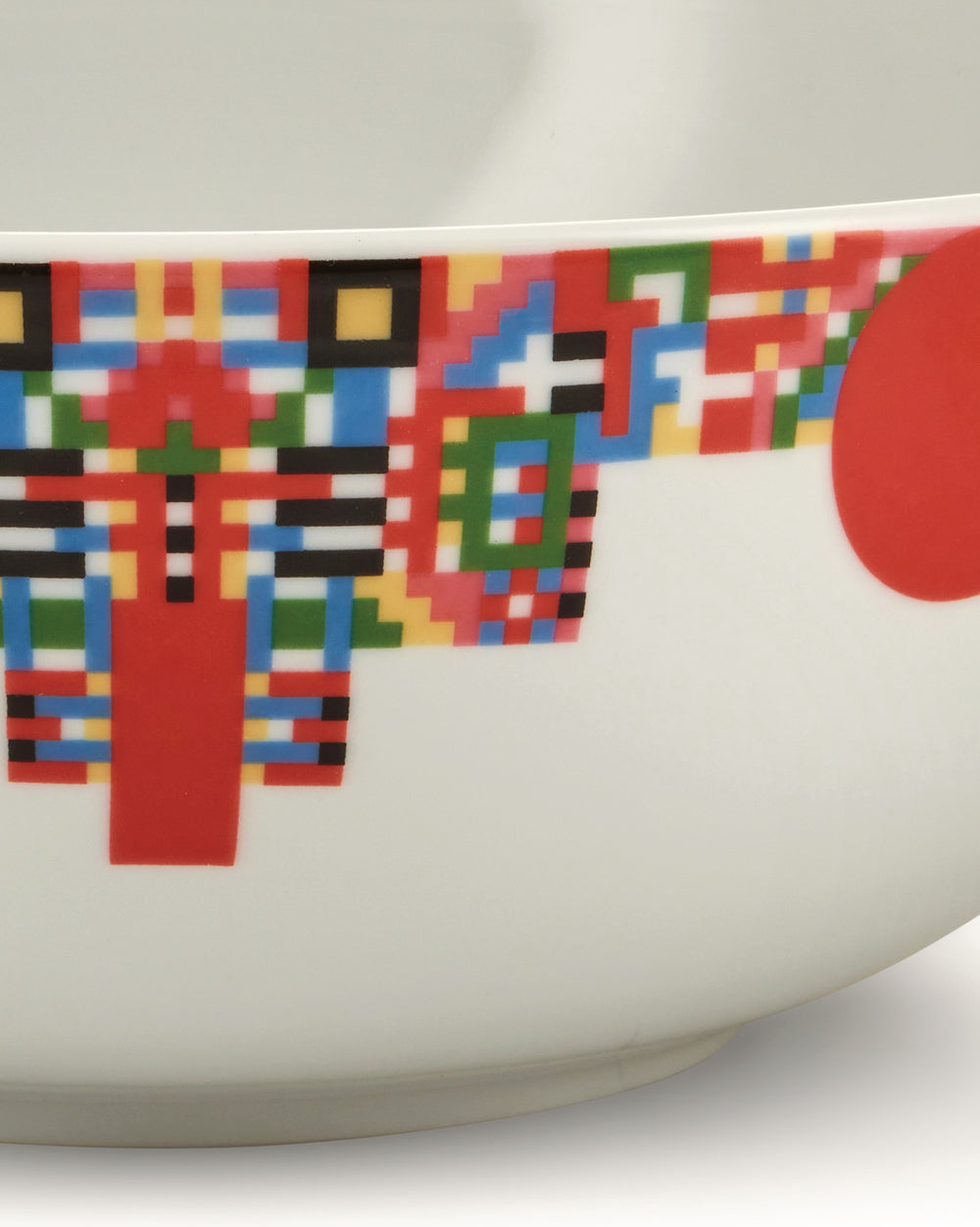 White ceramic bowl by Alessi, featuring a pixelated multicolor geometric pattern and a partial red circle.