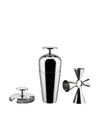 A polished stainless steel cocktail bar tool set by Alessi, featuring a shaker, strainer, and jigger, presented upright.