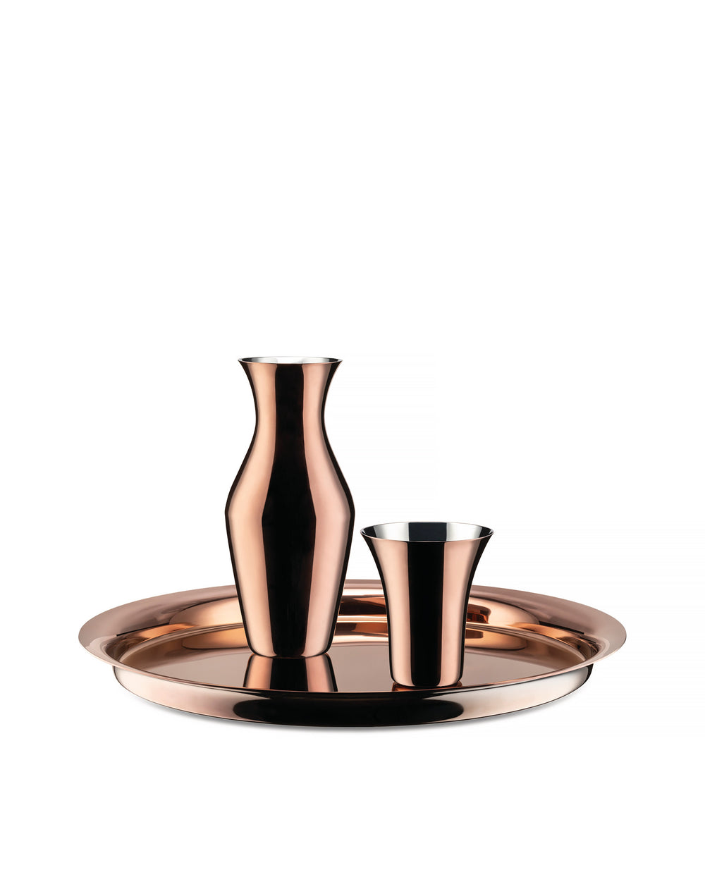 Polished copper pitcher by Alessi, accompanied by a tapered cup on a round tray.