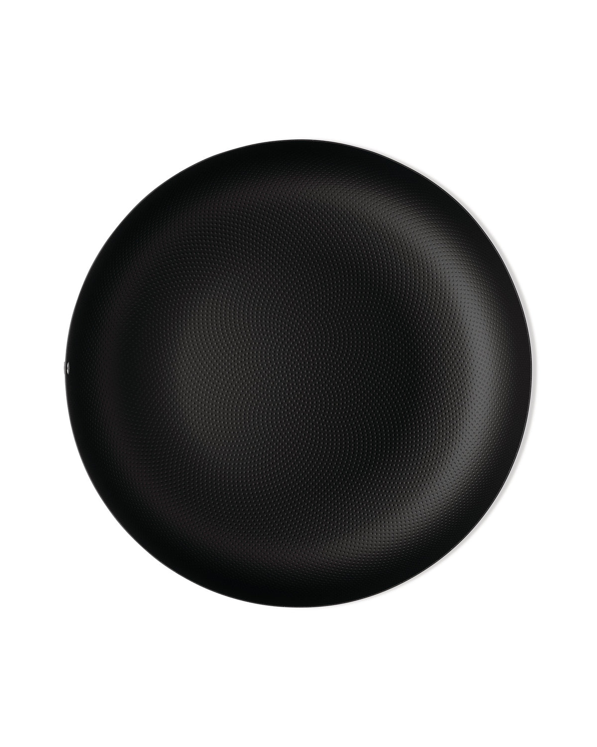 Black round plate by Alessi with a textured dimpled surface and thin white rim.