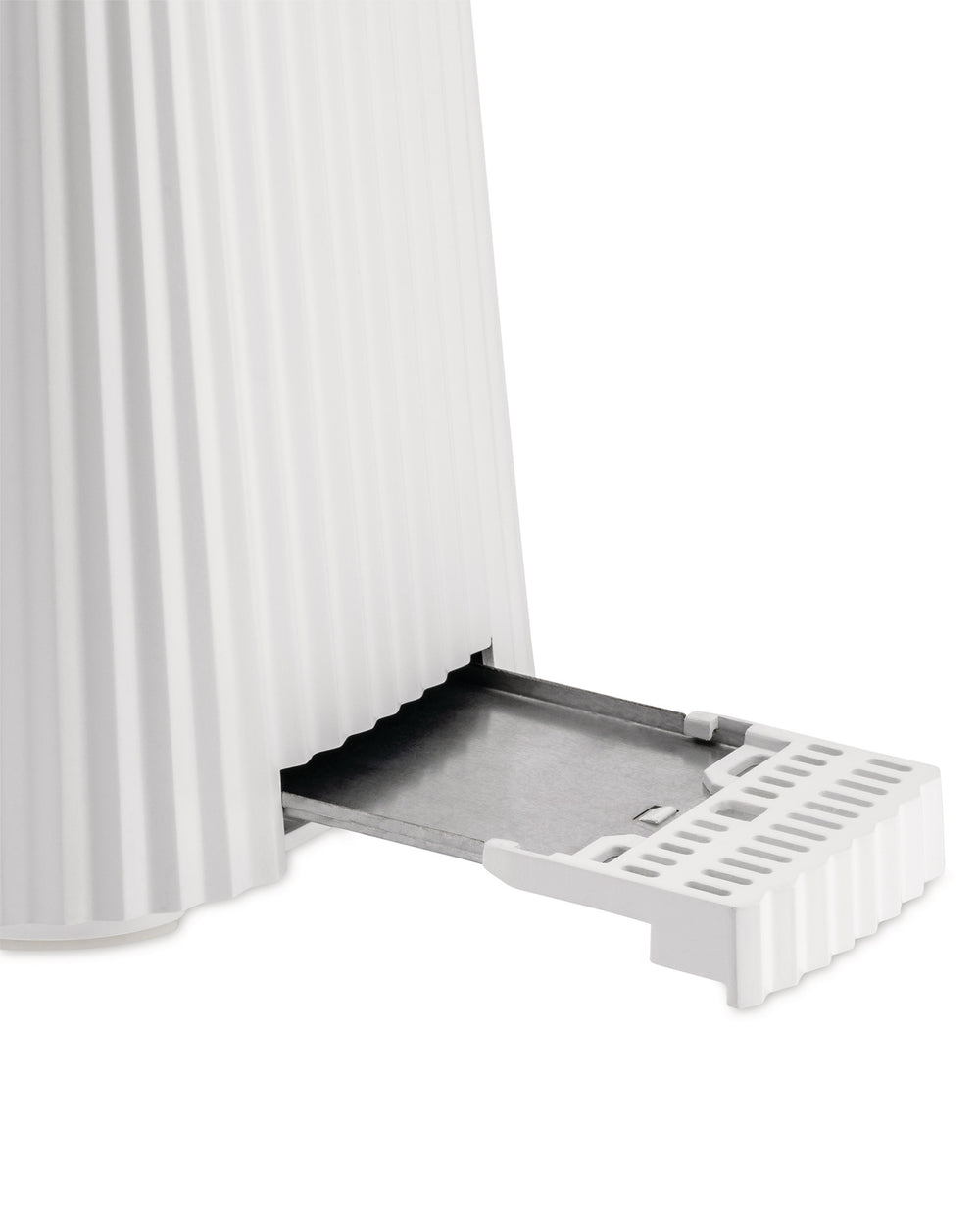 White pleated toaster by Alessi, with a silver crumb tray pulled out, shown in a side view.