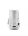White pleated coffee machine by Alessi with a transparent glass carafe and digital clock on a white background.