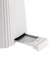 White ribbed toaster by Alessi with a metallic crumb tray partially pulled out.