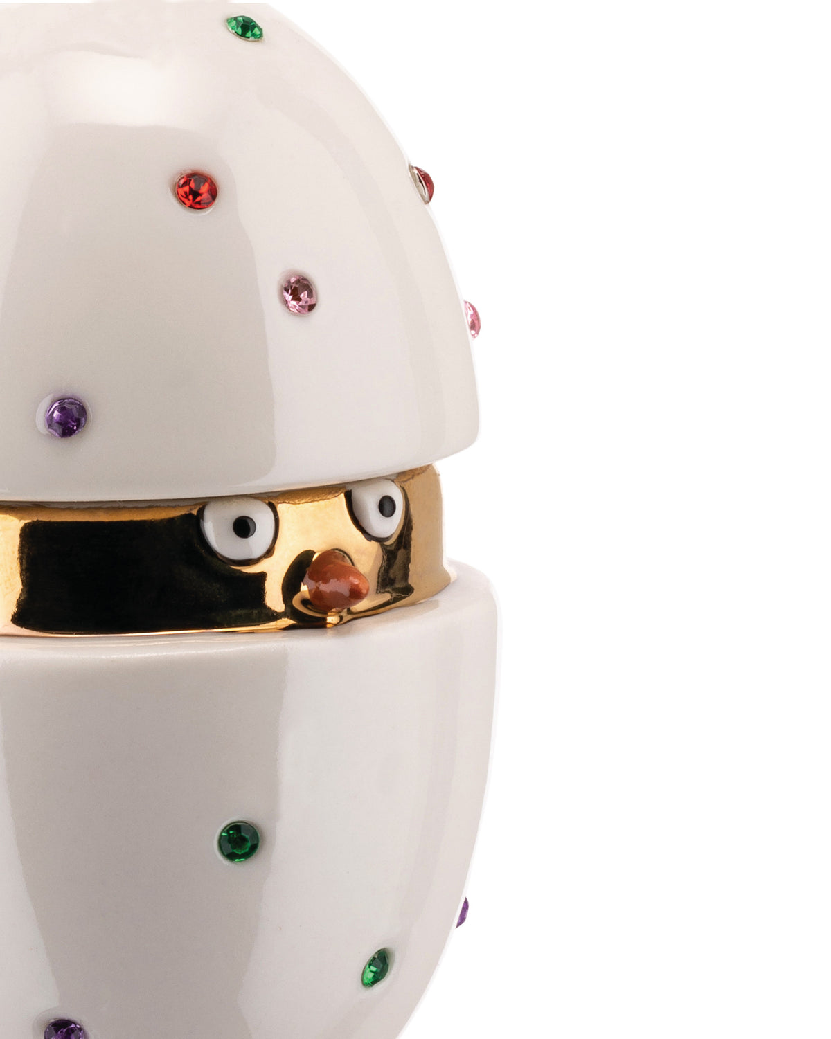 White ceramic chick egg container by Alessi, with a golden interior, colorful crystal embellishments, and a chick's face peeking out.