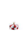 A round red and white striped container by Alessi, designed like a circus tent with a gold spherical handle.