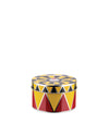 Round metal container by Alessi with red, yellow, and black circus-themed triangles and a monkey face on the lid.
