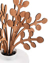Brown wooden scent diffuser by Alessi, featuring stylized leaf-like pieces in a white ceramic bowl.