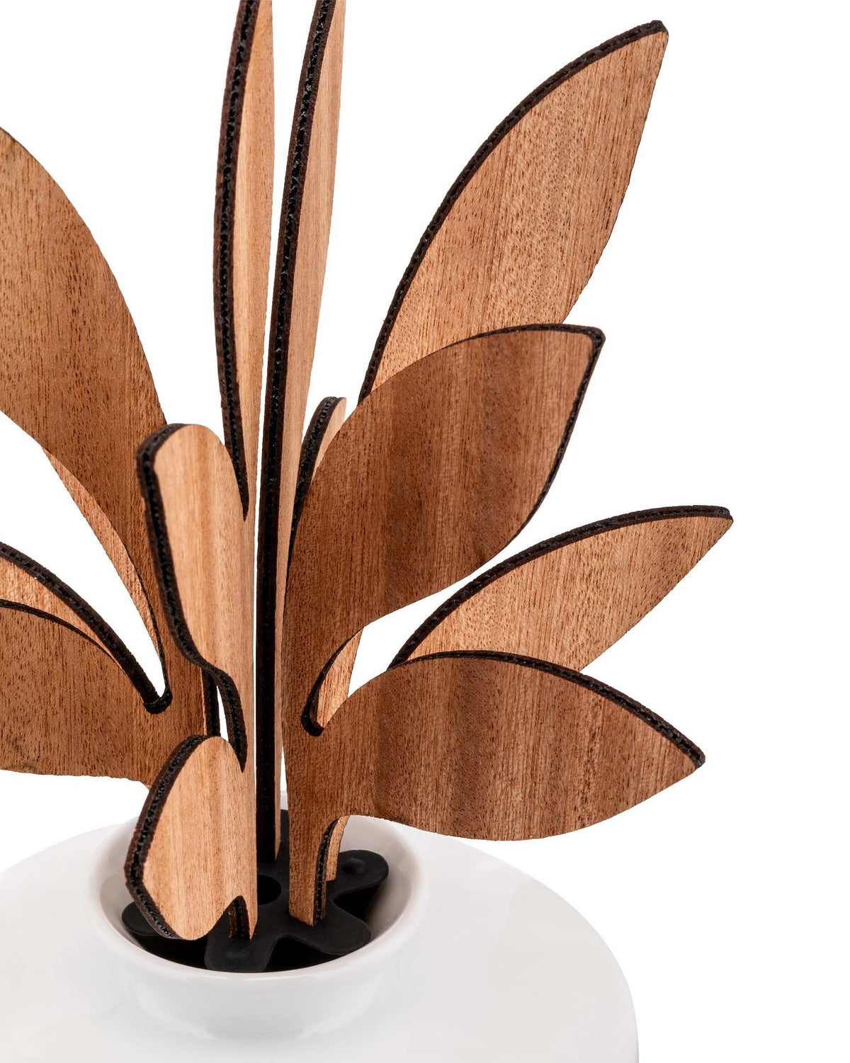 Wooden room diffuser by Alessi, featuring light brown leaf-shaped wooden pieces in a white base with a black holder.