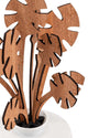 Brown wooden Monstera plant sculpture by Alessi, featuring laser-cut details and dark edges, in a white pot.