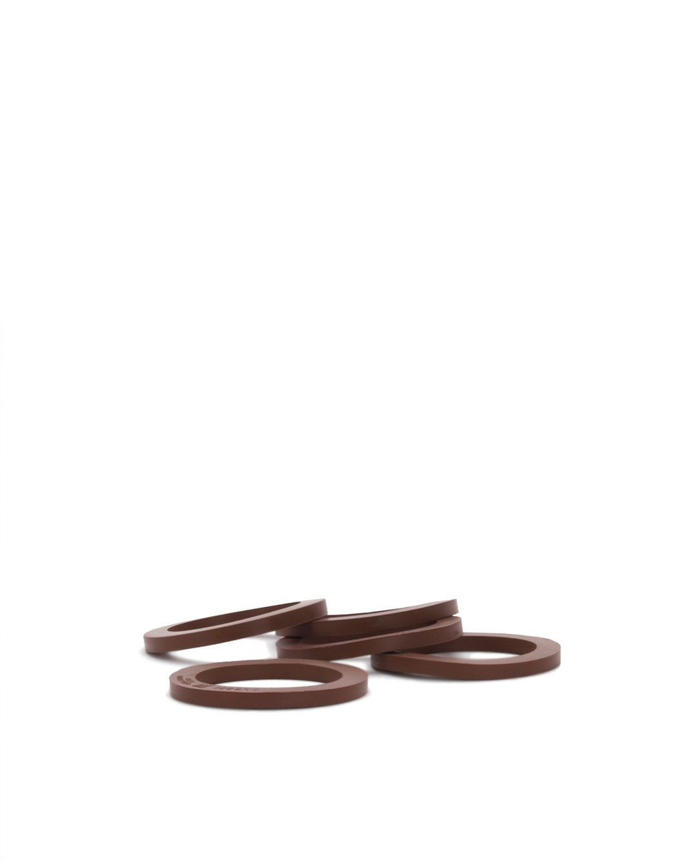 Brown circular spare part rings by Alessi, scattered and slightly overlapping on a white background.