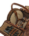 Brown wicker picnic basket by Alessi, filled with tan plates, clear glasses, black cutlery, and brown leather straps.