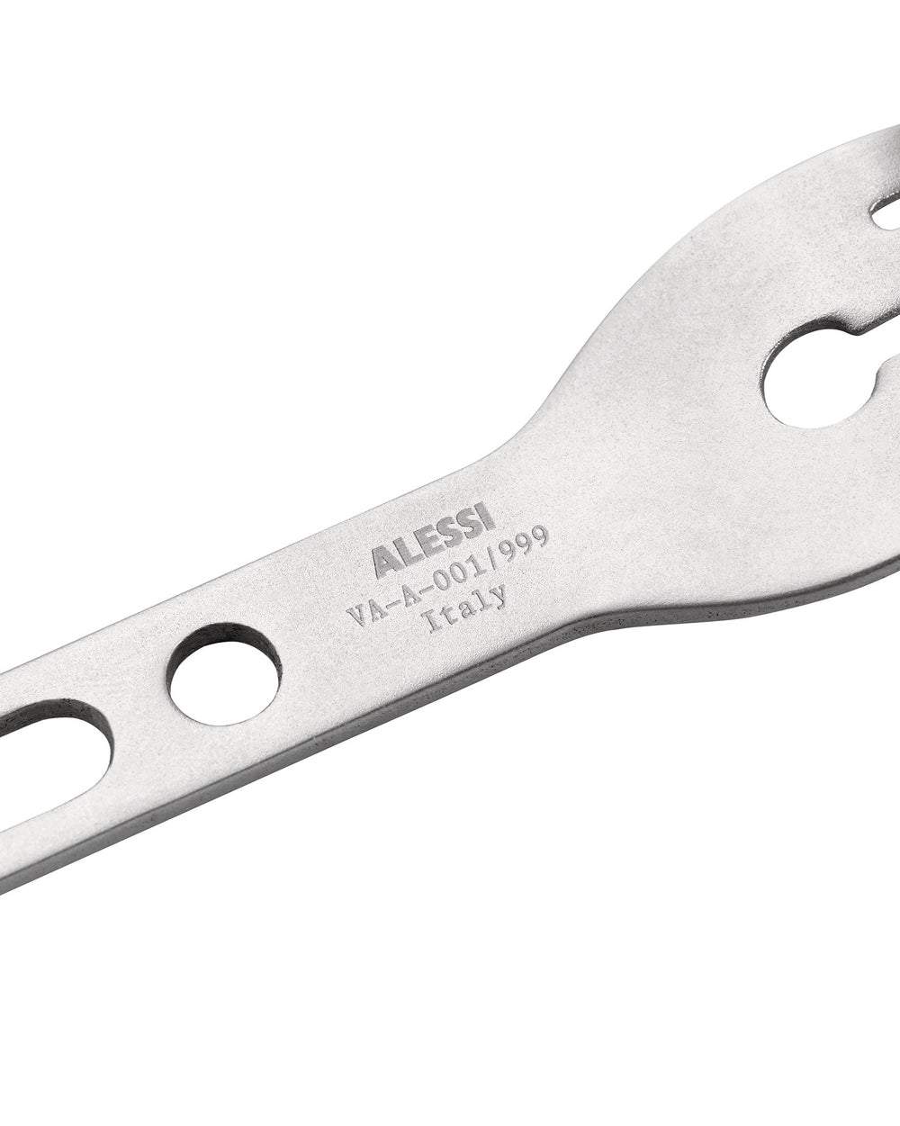 Silver-toned metallic occasional object by Alessi, with engraved text and cut-out details, in an angled close-up.