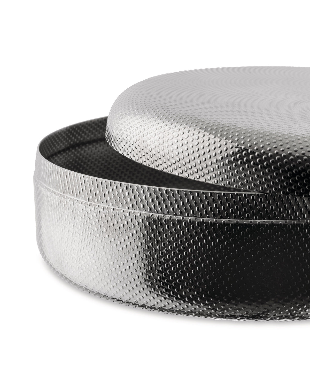 Silver round metal container by Alessi with perforated texture and slightly open lid.