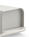 Light gray Mattina bread bin by Alessi, featuring a smooth matte finish and rounded edges, front right view.