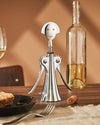 Silver metal corkscrew by Alessi, a smiling humanoid figure with lever arms and a fluted base.